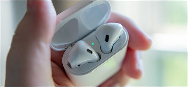 Apple AirPods case open with the status light on