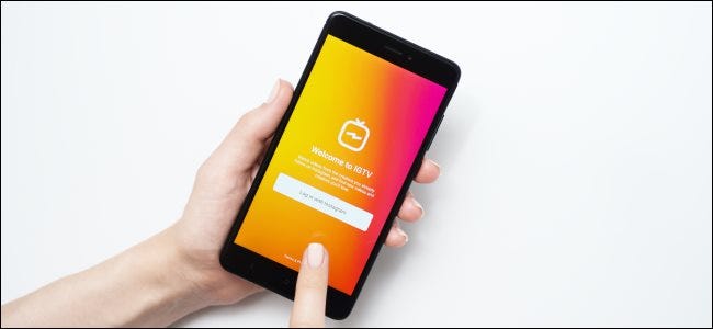 A finger tapping the IGTV app login screen on a phone.