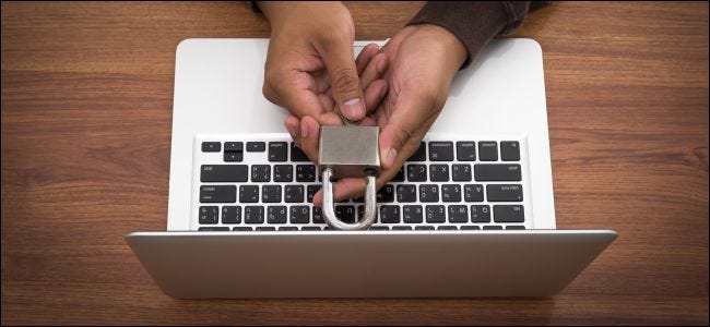 Hands holding a lock over a MacBook