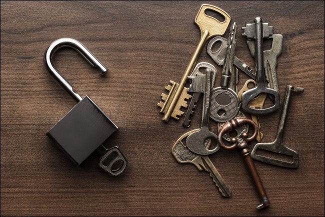 Multiple keys next to an open padlock.