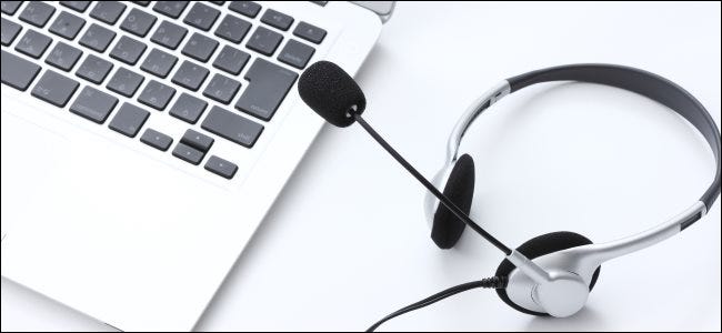 An audio headset with a microphone next to a MacBook keyboard.