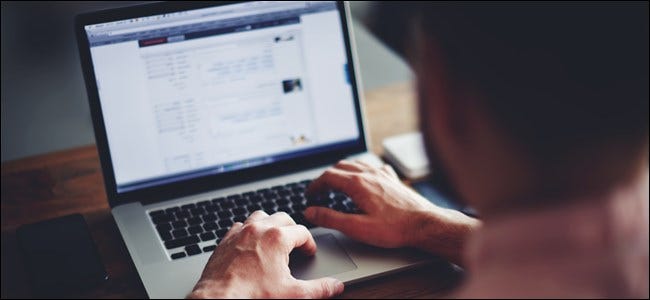 Man typing on laptop keyboard.