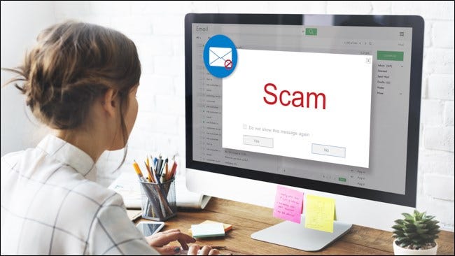 A woman opening an email on her computer that says Scam.