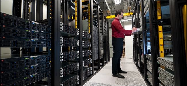 An IT administrator installing a rack-mounted server in a data center.