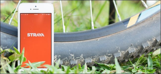 The Strava app on a smartphone next to a bicycle tire.