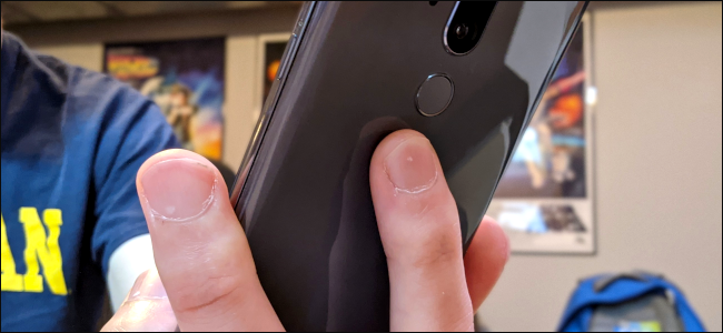 Someone's fingers on the back of an android phone.